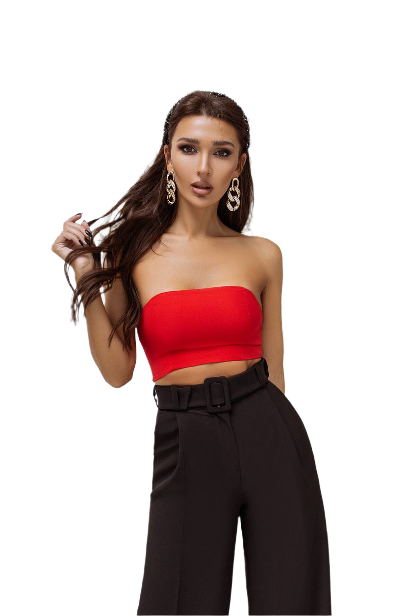 Woman wearing a red strapless top and black high-waisted pants on a white background