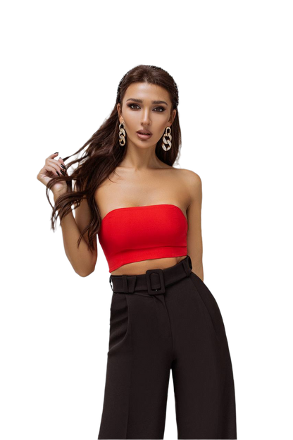 Woman wearing a red strapless top and black high-waisted pants on a white background