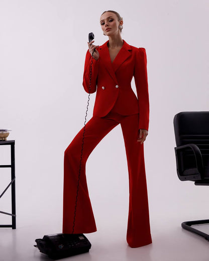 Person wearing a red suit holding a vintage phone on a white background