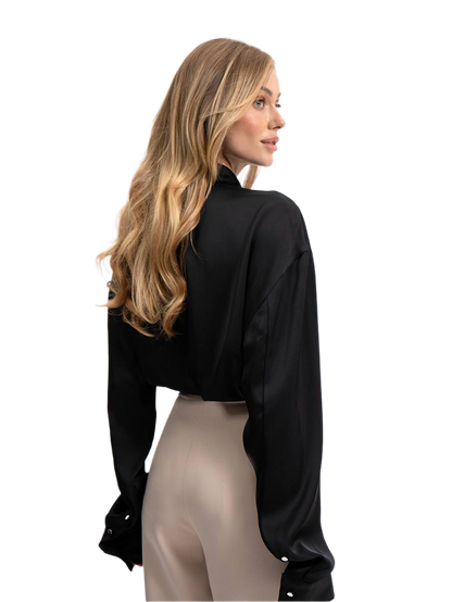 Woman wearing a black blouse and beige pants on a white background