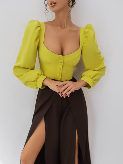Woman wearing a bright yellow top with puffed sleeves and a brown skirt on a white background