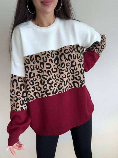Person wearing a sweater with a leopard print pattern on a plain background