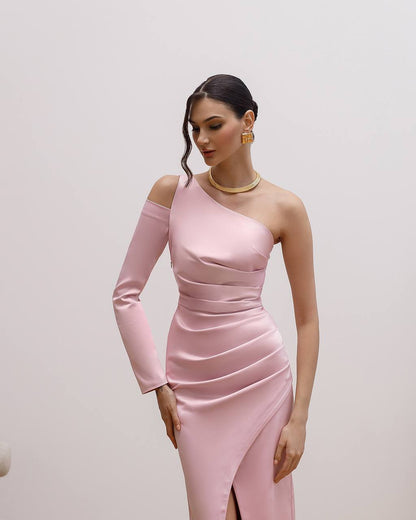 Woman wearing a pink one-shoulder dress with a plain background