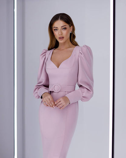 Woman wearing a pink dress with puffed sleeves against a light gray background