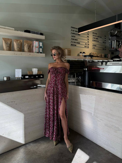 Woman in a floral dress standing in a modern cafe.