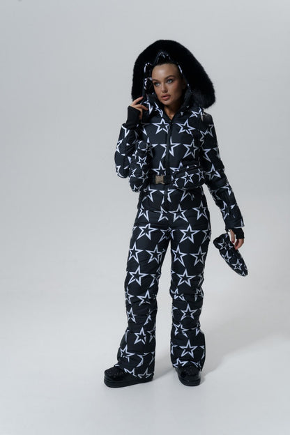 Person wearing a black and white star-patterned snowsuit on a white background