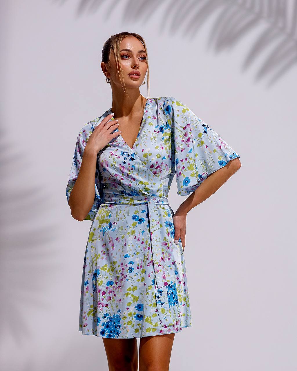 Woman wearing a floral dress against a plain background