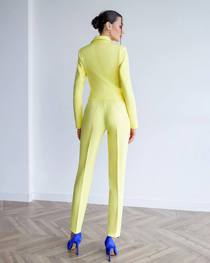 Person wearing a bright yellow suit standing on a wooden floor with a white wall background