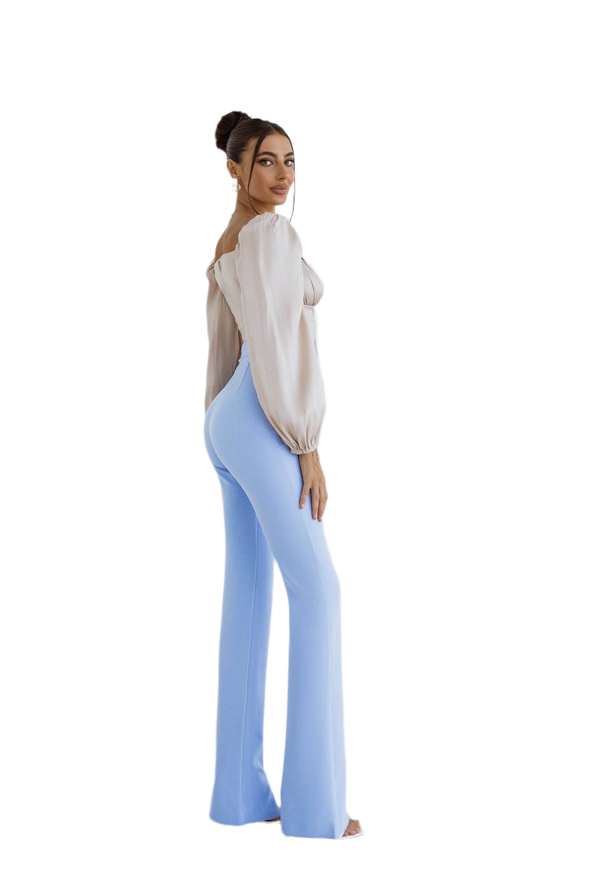 Woman wearing a white blouse and light blue flared pants on a white background