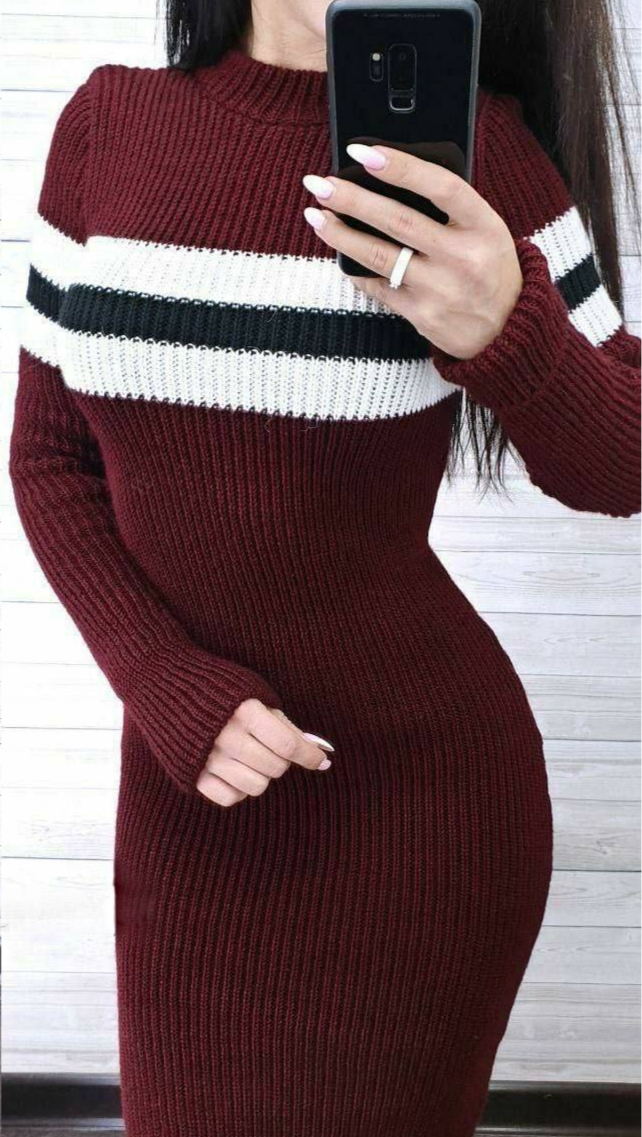 Person wearing a burgundy sweater with white and black stripes, taking a selfie.