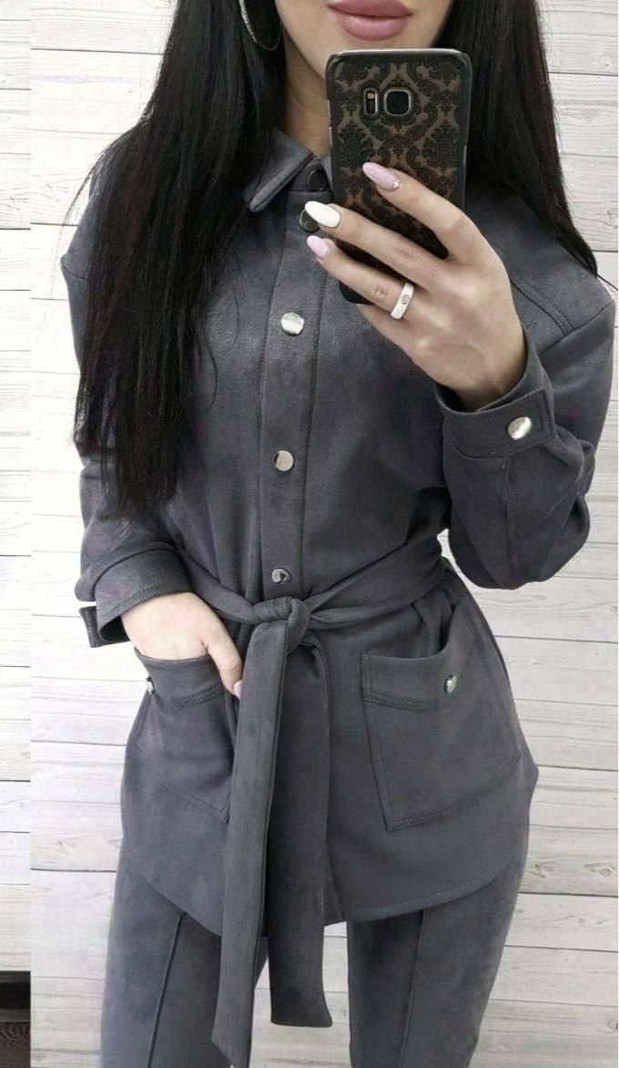 Person wearing a gray coat taking a mirror selfie.