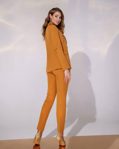 Woman wearing a mustard yellow suit against a white background