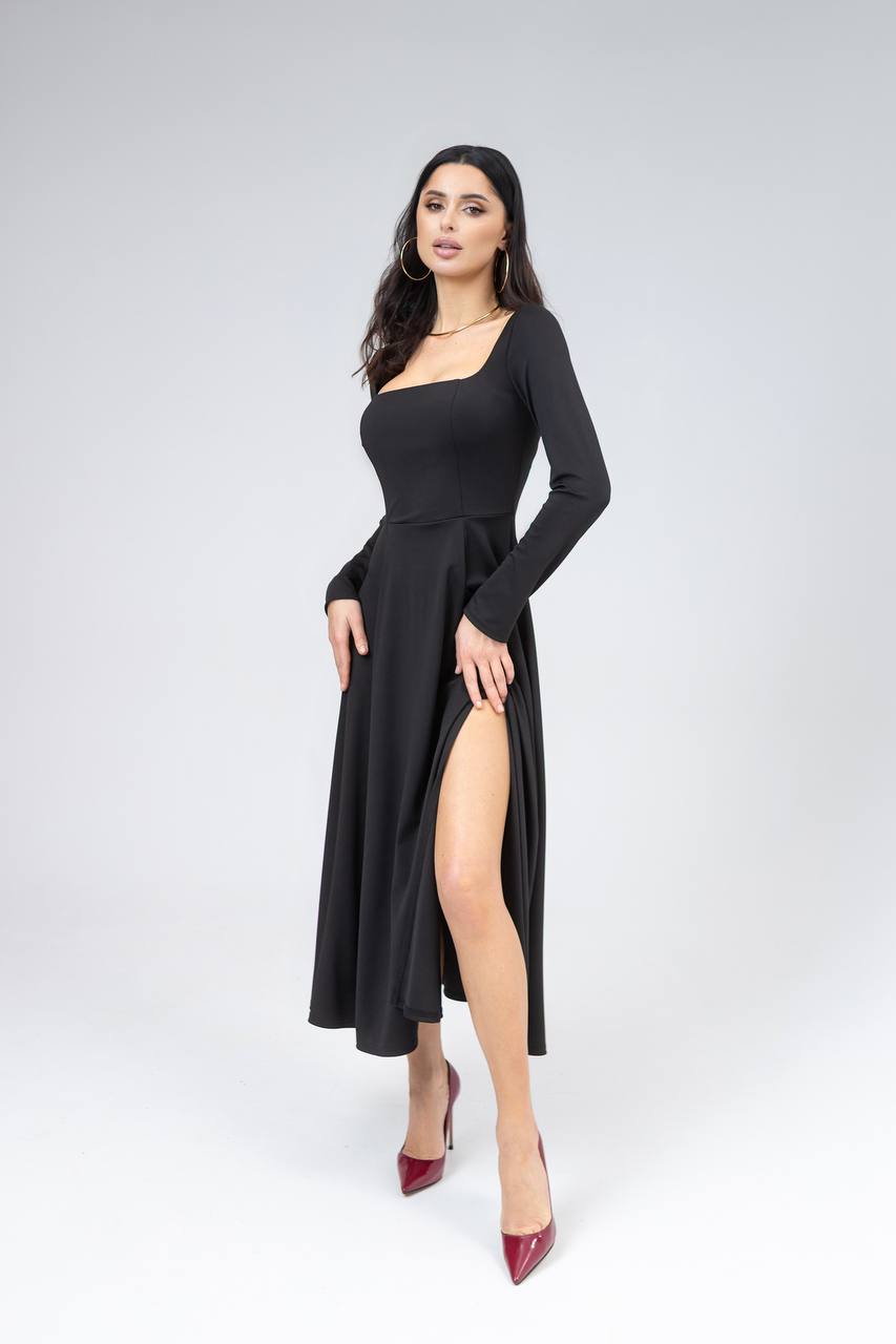 Woman wearing a black dress with a slit on a white background