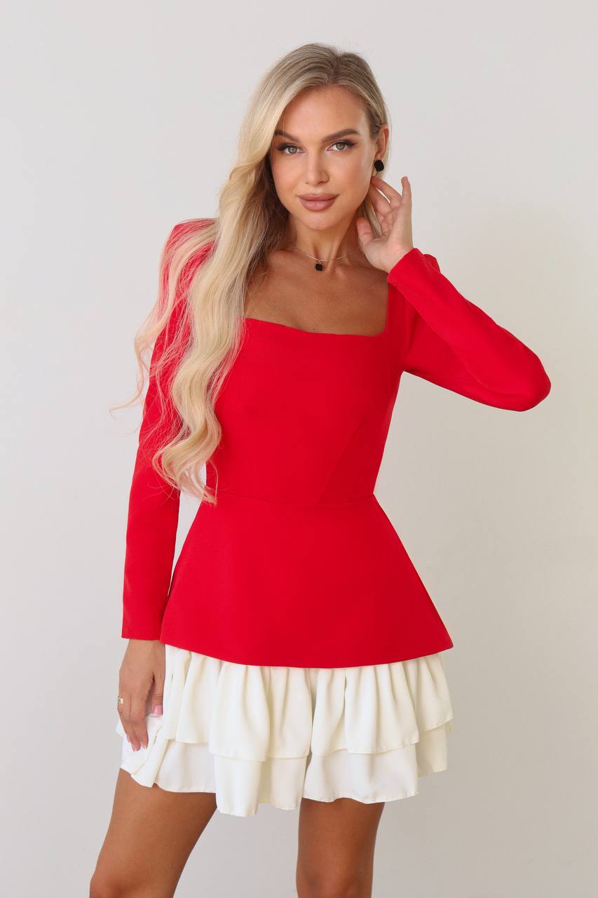 Woman wearing a red top and white skirt against a plain background