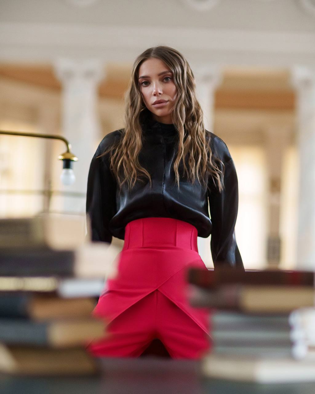 Woman wearing a black top and red skirt in an indoor setting