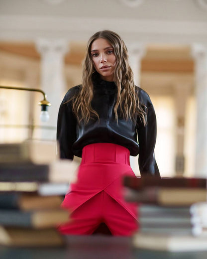 Woman wearing a black top and red skirt in an indoor setting