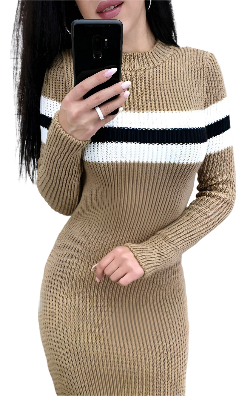 Woman wearing a beige sweater dress with white and black stripes, holding a phone.