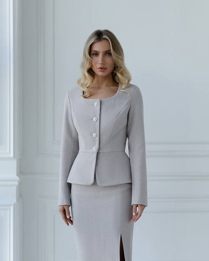 Woman wearing a light gray suit with a white background
