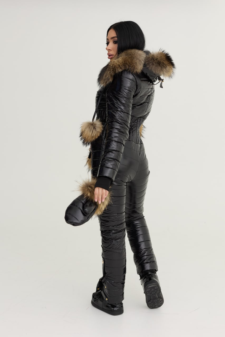 Person wearing a black winter suit with fur accents on a white background