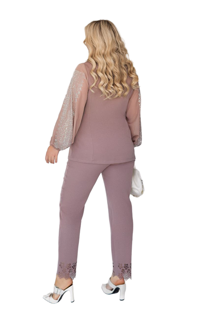 Woman wearing a mauve outfit with sheer sleeves on a white background