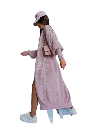 Person wearing a long pink cardigan with a white background