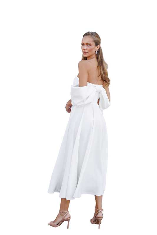 Woman wearing a white dress with a plain background