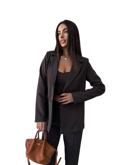 Woman wearing a dark suit holding a brown handbag on a white background