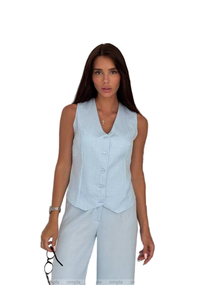 Woman wearing a light blue sleeveless top and pants on a white background