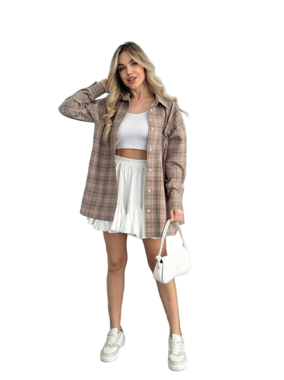 Woman wearing a plaid shirt, white top, and skirt with a white handbag on a white background