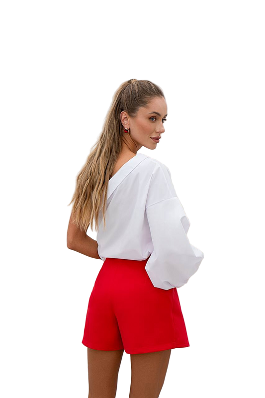 Woman wearing a white blouse and red shorts on a white background
