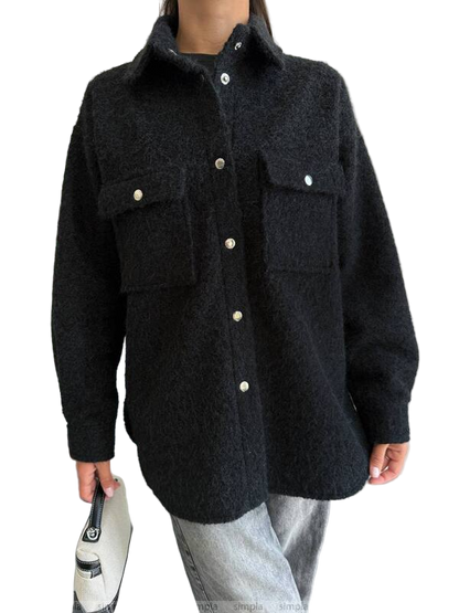 Person wearing a dark gray jacket with button details on a white background