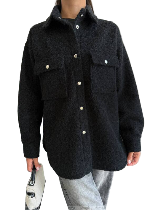 Person wearing a dark gray jacket with button details on a white background