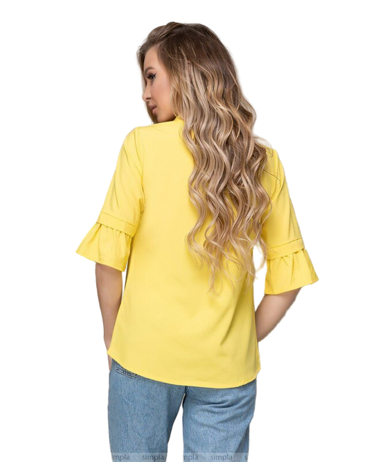 Woman wearing a yellow blouse with ruffled sleeves on a white background