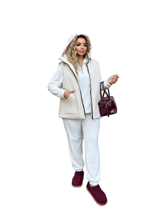 Woman wearing a beige and white outfit with burgundy shoes and handbag on a white background