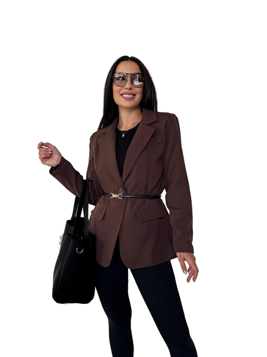 Woman wearing a brown blazer and black pants with a black handbag on a white background