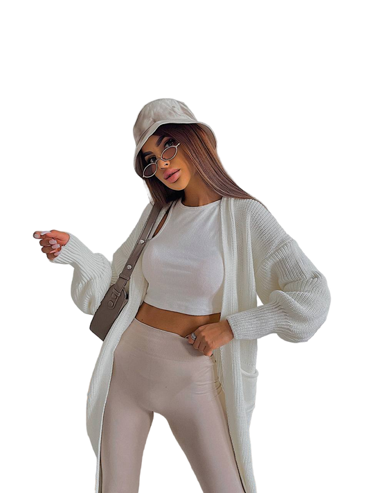 Woman wearing a beige outfit with a cardigan, top, and pants on a white background