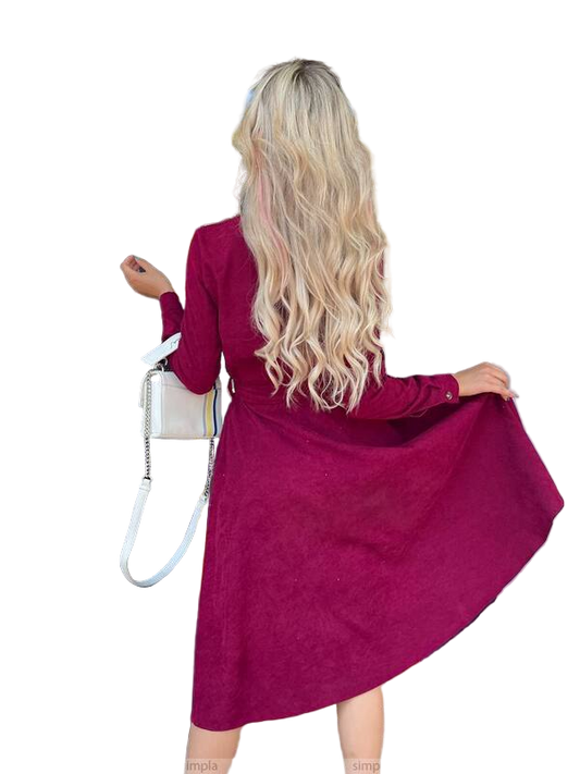 Woman wearing a magenta dress with long sleeves on a white background
