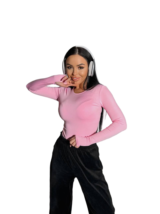 Person wearing a pink long-sleeve top and black pants on a white background