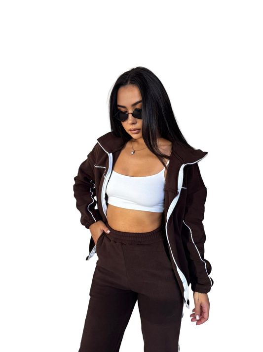 Woman wearing a brown jacket and pants with a white top on a white background