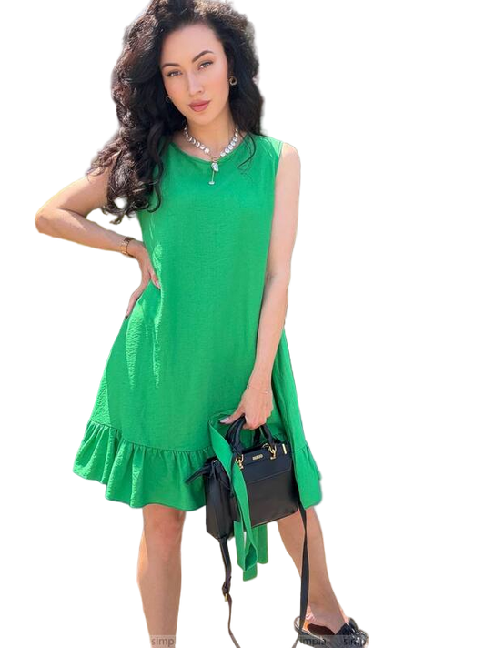 Woman wearing a green dress holding a black handbag on a white background