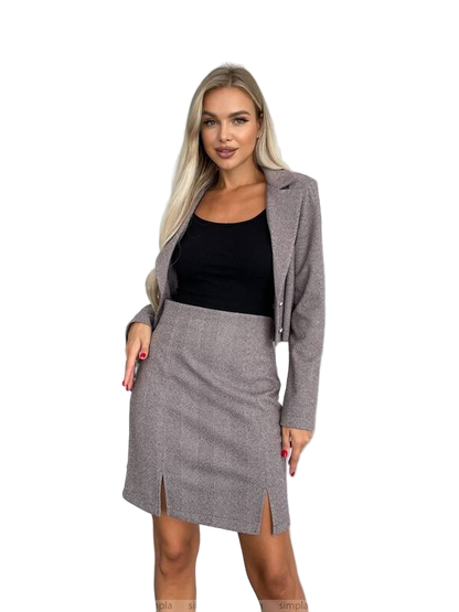Woman wearing a gray blazer and skirt set on a white background