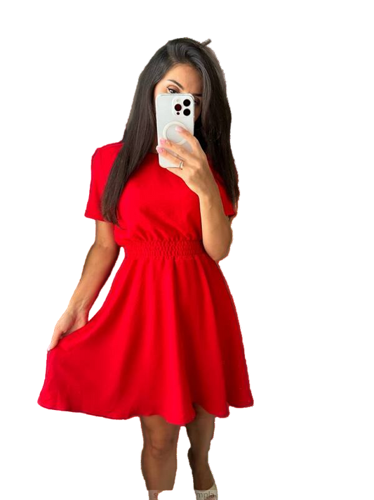 Woman wearing a red dress taking a mirror selfie on a white background