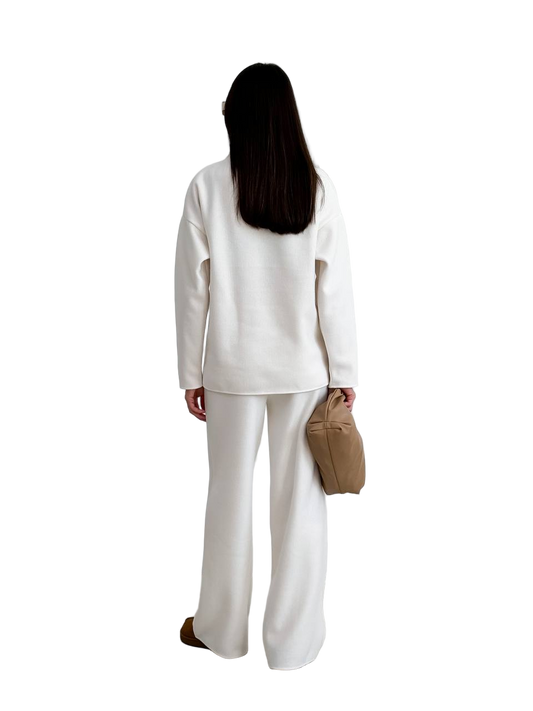 Person wearing a white outfit with a beige bag on a white background