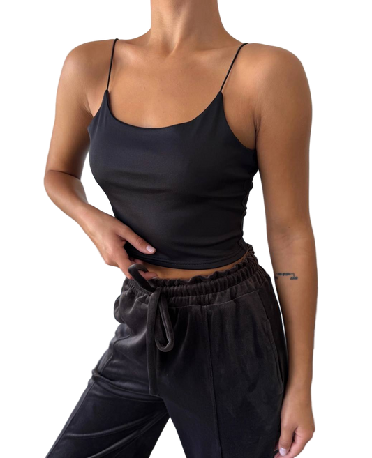 Person wearing a black tank top and black pants on a white background