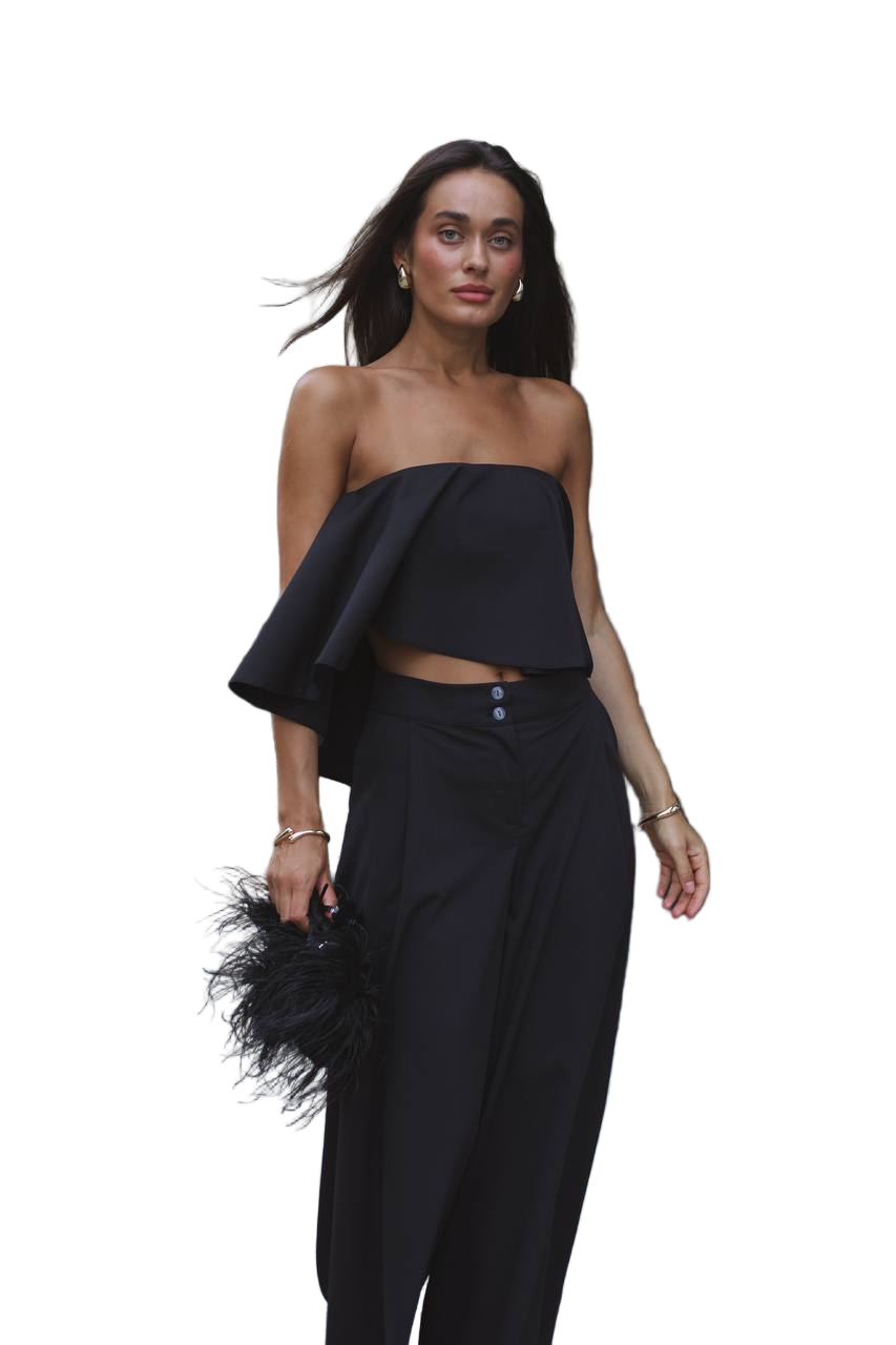 Woman wearing a black strapless top and black pants on a white background