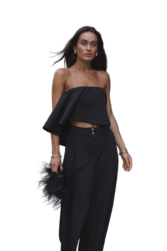 Woman wearing a black strapless top and black pants on a white background