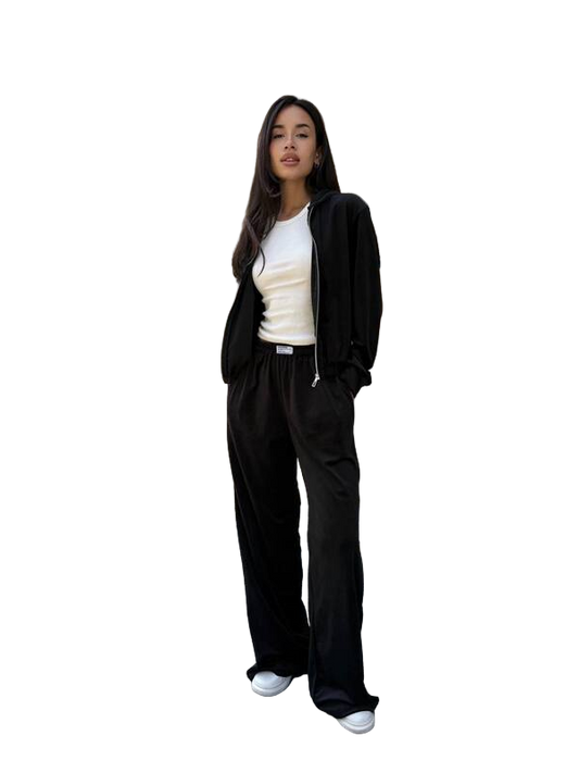 Person wearing a black tracksuit with a white shirt on a white background