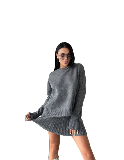 Woman wearing a gray sweater and skirt set on a white background