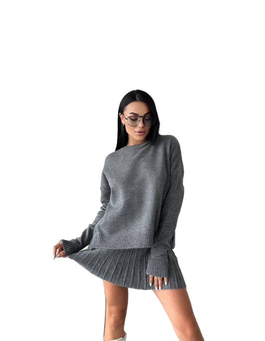 Woman wearing a gray sweater and skirt set on a white background