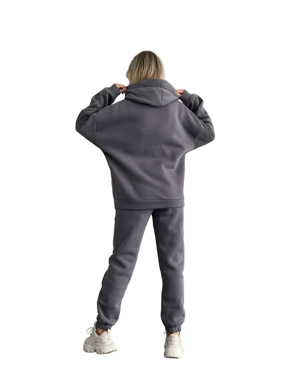 Person wearing a gray tracksuit on a white background
